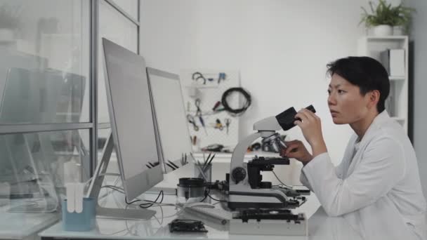 Tracking Shot Tecnico Laboratorio Femminile Asiatico Microscopio Mentre Ingegnere Elettronico — Video Stock