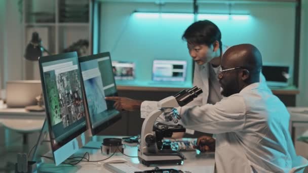 Různí Technici Diskutující Obrázky Obrazovce Počítače Připojené Mikroskopu Při Vývoji — Stock video