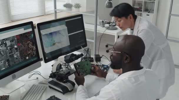 기사보기 아프리카 미국인 기술자 실험실에서 협력하는 컴퓨터 거시적 이미지를 토론하는 — 비디오