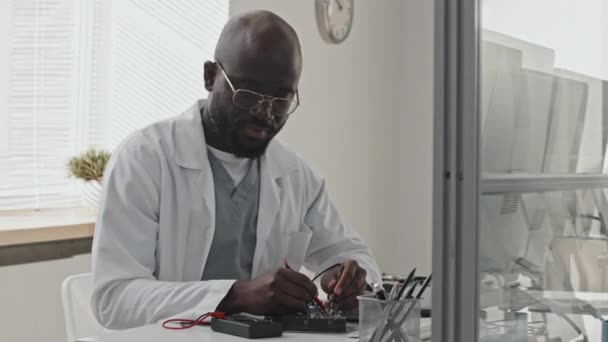 Elektroniği Test Etmek Için Multimetre Kullanan Beyaz Önlüklü Afrikalı Amerikalı — Stok video