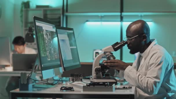 Engenheiro Afro Americano Usando Microscópio Conectado Computador Enquanto Examina Eletrônica — Vídeo de Stock