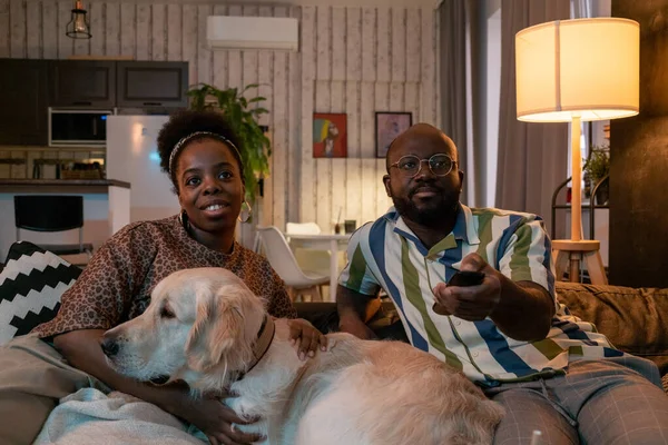 Casal africano com cão assistindo TV — Fotografia de Stock