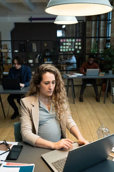 Mujer embarazada trabajando en la computadora en la oficina — Foto de Stock