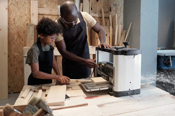 Padre e hijo cortando madera en taller — Foto de Stock