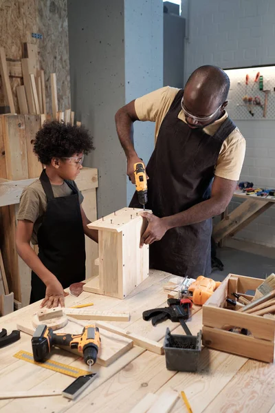 Чорний чоловік з сином у столярній майстерні — стокове фото