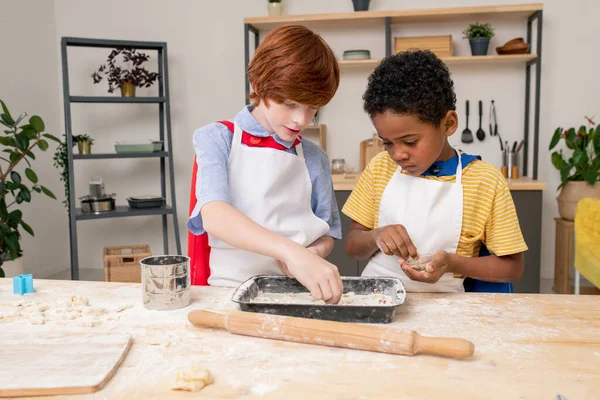 Kinderen rollen deeg tijdens het koken zelfgemaakt gebak — Stockfoto