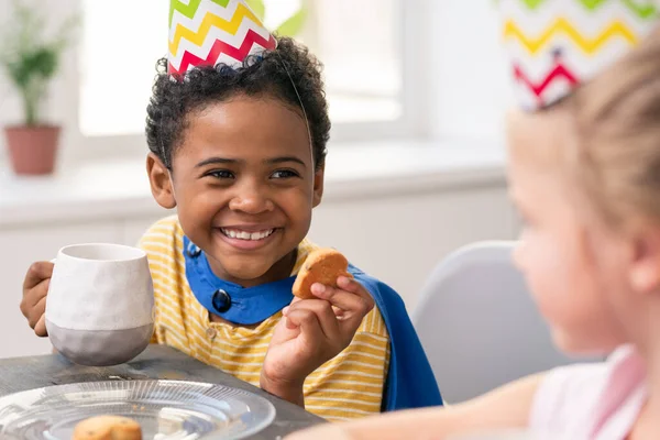 Aranyos kisfiú lisztet szitál tálkára, miközben tésztát csinál süteménynek. — Stock Fotó