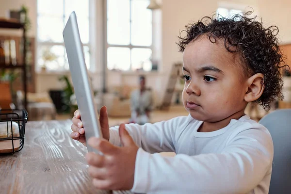 Niño pequeño concentrado usando la aplicación de la tableta — Foto de Stock