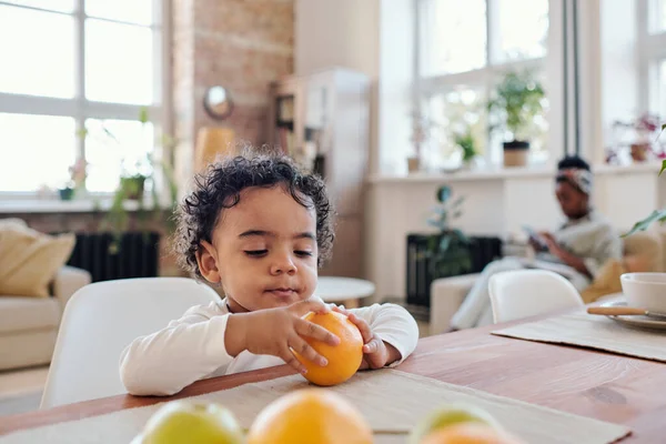 Liten pojke som skalar orange — Stockfoto