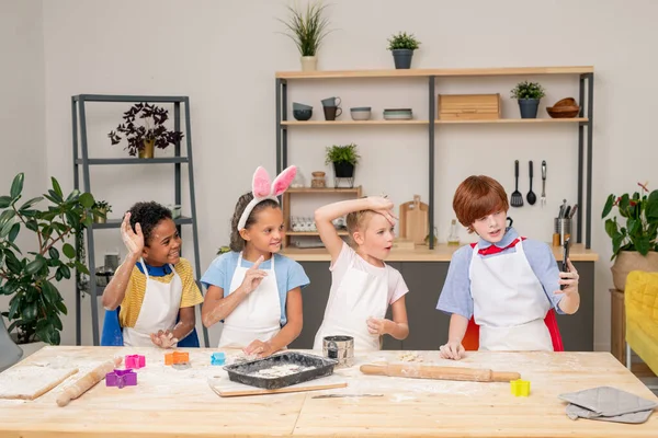 Kleiner Junge verquirlt Mehl mit rohen Eiern in Schüssel für Schüssel, während er Mama hilft — Stockfoto