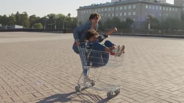 Traceren Van Een Energieke Blanke Man Denim Kleren Duwen Winkelwagen — Stockvideo