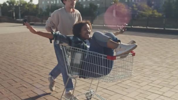 Tracking Van Vrolijke Blanke Mannelijke Student Duwen Winkelwagen Met Zorgeloze — Stockvideo