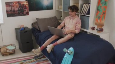 Yatağında oturan, taşınabilir bilgisayarda yazan, sonra da kapayan, plastik kaykayı alıp gündüz vakti yürüyüp giden kıvırcık saçlı genç beyaz adamın izini sürmek.