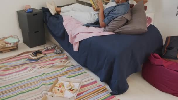 Нахил Чорної Дівчини Початку Двадцятих Лежав Ліжку Читаючи Книгу Спальні — стокове відео