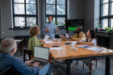 Genç kendine güvenen işletme koçu seyircilerin önünde sunum yapıyor.