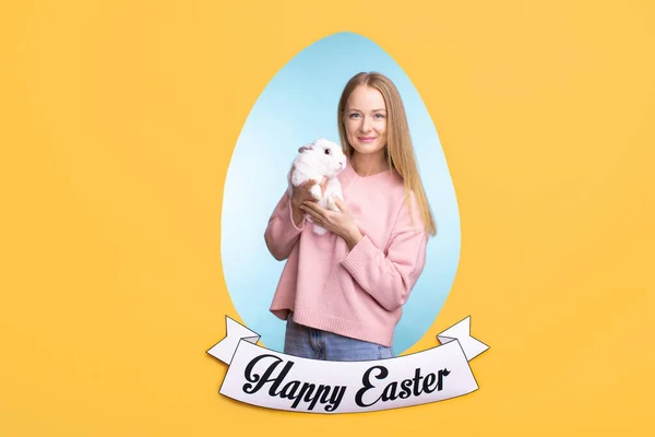 快乐的年轻漂亮的女性，穿着粉色毛衣，抱着复活节兔子 — 图库照片