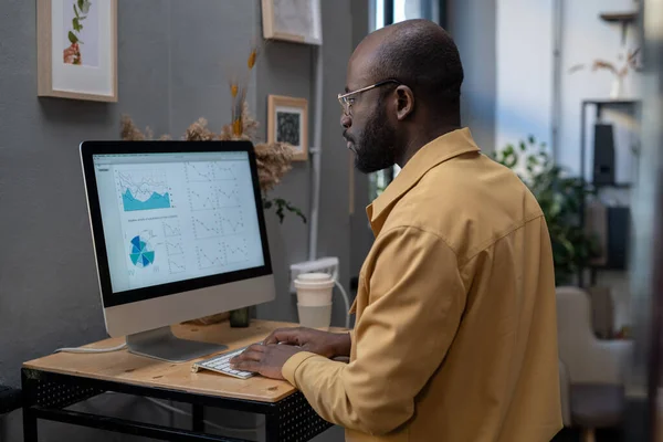 現代アフリカ系アメリカ人のビジネスマンがコンピュータの前に座っている — ストック写真