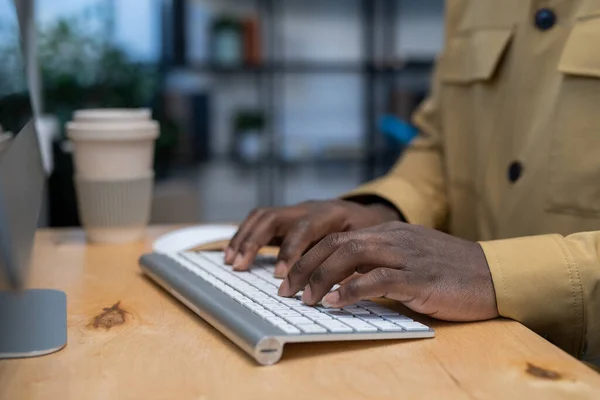 Manos del joven empresario afroamericano presionando las teclas del teclado de la computadora — Foto de Stock