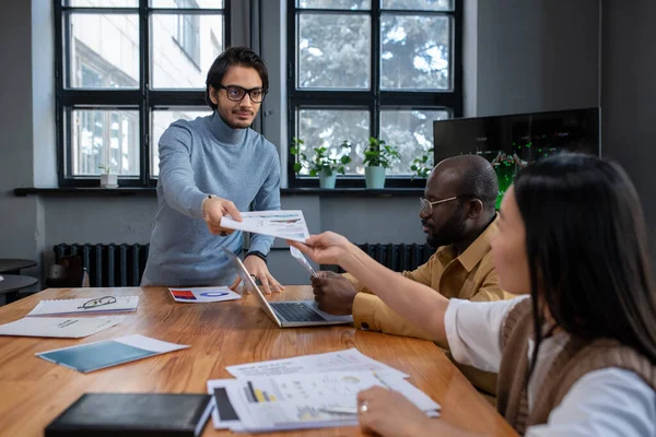 Young confident speaker passing document to colleague before presentation — Stock Photo, Image