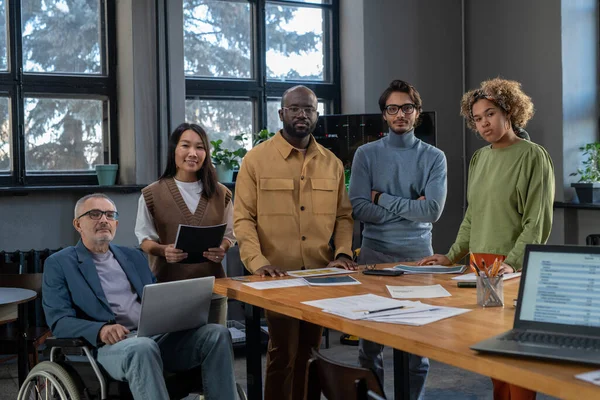 Group of multiracial colleagues standing by table in boardroom — Stock Photo, Image