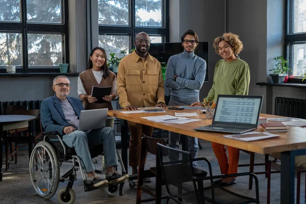 Cheerful economists of various ethnicities gathered by workplace — Stock Photo, Image