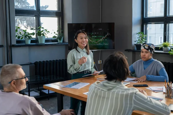 Young successful Asian speaker communicating with audience — Stock Photo, Image