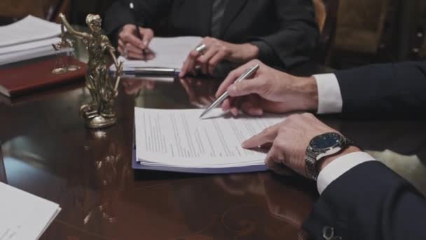 Közelkép szakmai ügyvéd kezét olvasási szerződést, és elmagyarázza annak részleteit, hogy a kollégák vagy ügyfelek a fa iroda asztal