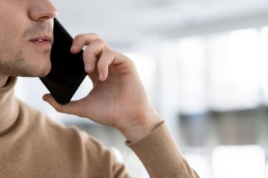 Akıllı telefonlu bir yönetici ya da yöneticinin yüzü ve eli.