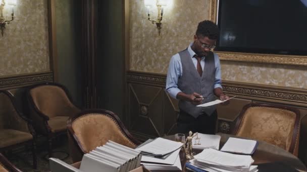 アフリカ系アメリカ人の弁護士が事務所で働いている間 カメラの書類を読み ポーズをとる — ストック動画