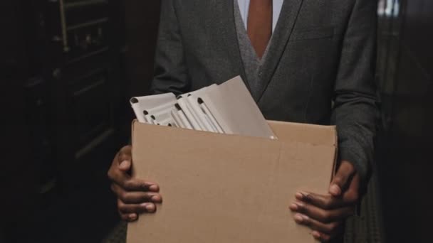 特写镜头 一个身份不明的非裔美国商人在离职或当档案管理员的时候 带着一盒文件夹穿过办公中心走廊 — 图库视频影像