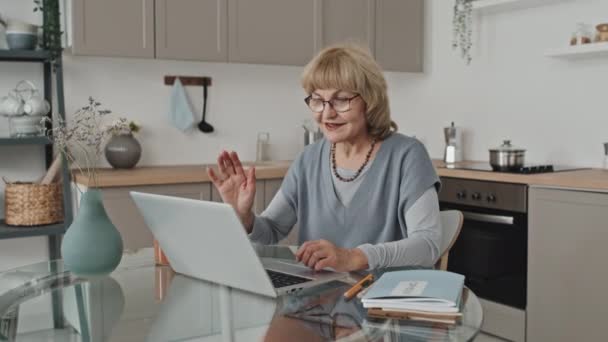 Senior Vrouw Zitten Aan Tafel Keuken Spreken Met Online Tutor — Stockvideo