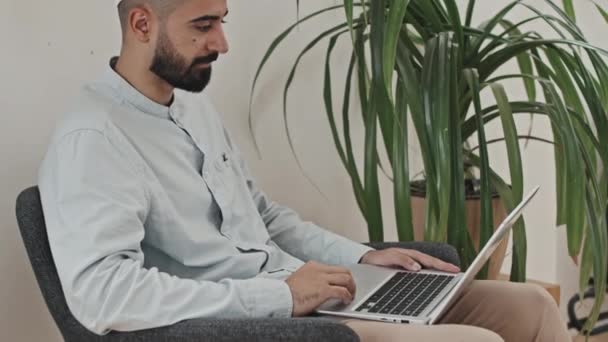 Naklonit Záběr Muslimského Muže Kufi Sedí Křesle Doma Mluví Video — Stock video