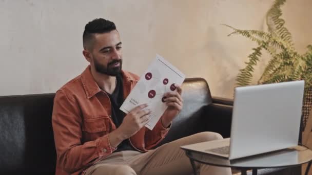 Middle Eastern Man Sitting Sofa Living Room Explaining Map Infographics — Stock Video