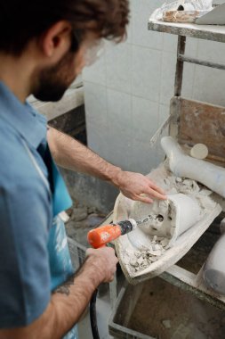 Protez fabrikası sondaj alçısının genç işçisinin açısının üstünde.