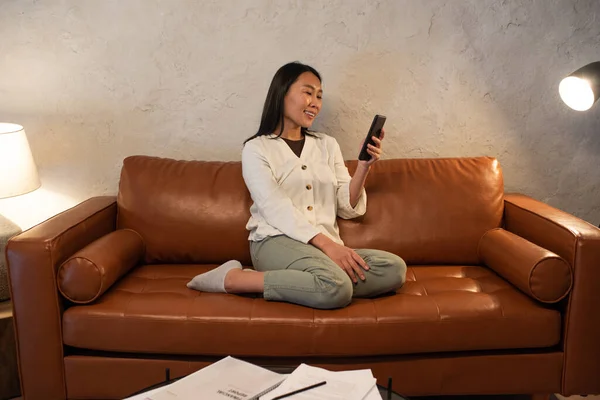Młoda uśmiechnięta kobieta azjatyckiego pochodzenia komunikująca się w czacie wideo — Zdjęcie stockowe