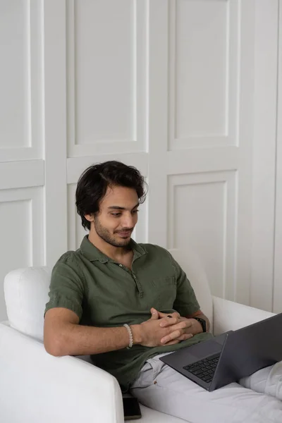 Молодой современный сотрудник смотрит на экран ноутбука во время цифровой встречи — стоковое фото