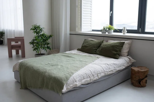 Двуспальная кровать с подушками белого и зеленого цветов и серого цвета — стоковое фото
