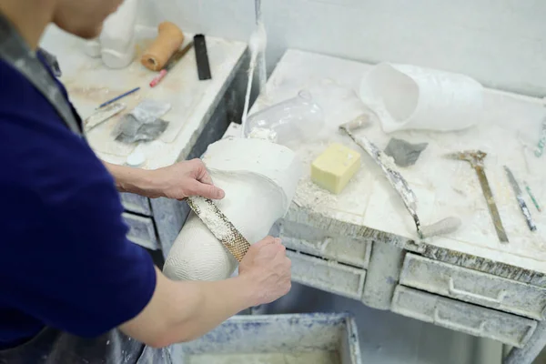 Above shot of hands of factory worker with chisel polishing plaster cast — Stock Photo, Image