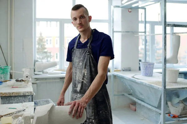 Contemporary young man in apron looking at camera during working process — Stock Photo, Image