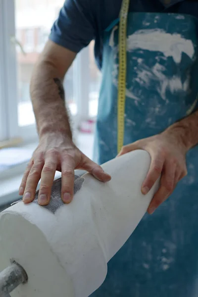 Ręka męskiego specjalisty w obróbce fartucha gipsowo-kartonowego odlewanego w warsztacie — Zdjęcie stockowe
