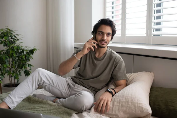 Jovem empregado ocupado contemporâneo ou freelancer falando no telefone celular — Fotografia de Stock