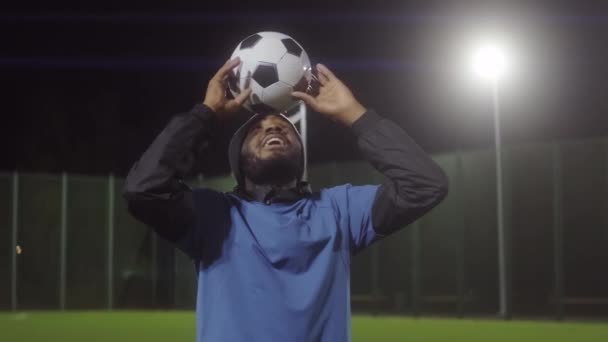 Pas Radosnego Młodego Afroamerykanina Sportowca Mundurze Ciepłym Kapeluszu Trzymającego Piłkę — Wideo stockowe