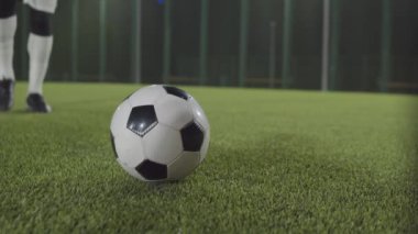 Krampon takan, futbol topunu yeşil çimlerde tekmeleyen bir sporcu.
