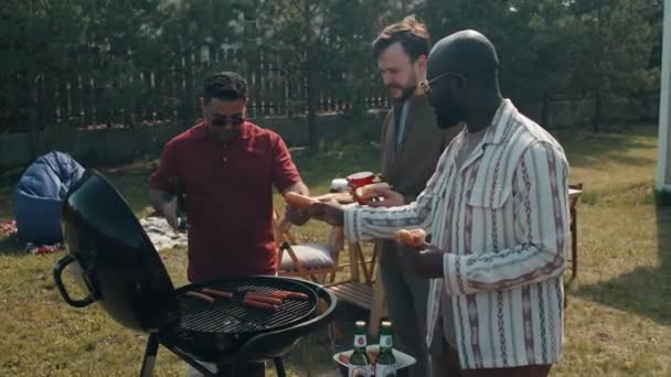 Üçüncü Grup Arka Bahçede Durmuş Sosisli Sandviçleri Izgarayla Hazırlarken Birlikte — Stok video