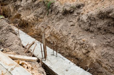 Metal takviyeli ve betonlu temeli hazırlayın. Çit tabanı. İnşaat süreci. İstinat duvarını inşa ediyorum. Toprak işi. Arkaplan. Uzayı kopyala Hiç kimse. Pankart.