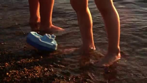물에서 장난감 보트를 가지고 실루엣 여름날 여행을 바다에서 긍정적 — 비디오