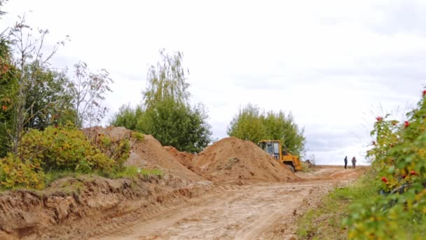 ベラルーシ ミンスク 2021年10月8日 トラクターブルドーザー清掃地面 大規模な掘削機レベルの建設現場土地 新しい建物を作る バケットを使用したフロントエンドローダーは土壌と砂を移動します — ストック動画