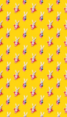 Paskalya tavşanı ve sarı arka planda izole edilmiş yumurta desenli. Komik bir doku. Eğitim oyuncak tiyatrosu çevrimiçi kursu. El kuklası. Dikiş hobisi. Peri masalı karakteri. Yumuşak bebek oyun arkadaşı.