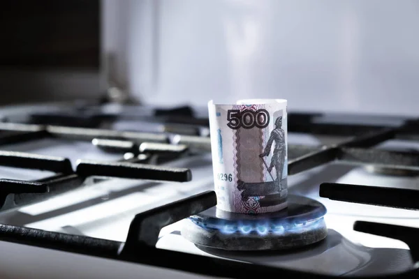 Concept of gas crisis. 500 russian ruble bank note is burning on a kitchen stove. Cash money. High prices of natural resources. Blue flame. Utility debt. Energy war. Saving home budget. Close-up.