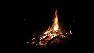 Siyah arka planda büyük, güzel bir şenlik ateşi. Gerçek alevler. Yanıyorum. Ateşlendi. Uzayı kopyala Yan görüş. Gece kamp ateşi. Turuncu renk. Doğa manzarası. Açık hava eğlencesi. Sonbahar bahçe temizliği. Sıcak.